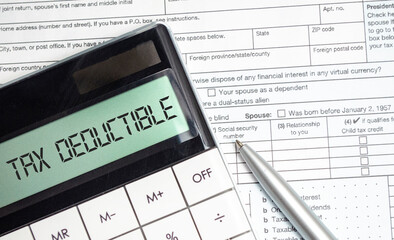 TAX DEDUCTIBLE word on calculator. Business and tax concept. Tax form