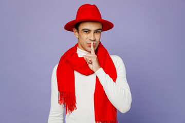 Young secret middle eastern man he wears white turtleneck red hat scarf say hush be quiet with...