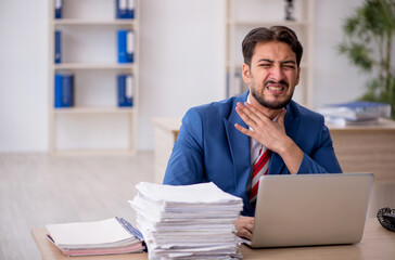 Young male employee and too much work in the office