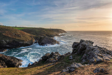 Obraz premium Stunning sunset landscape image of Cornwall cliff coastline with tin mines in background viewed from Pendeen Lighthouse headland