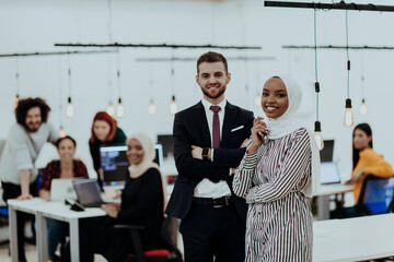 Portrait of a formal businessman and young African American businesswoman posing with their team in a modern startup office. Marketing concept. Multi-ethnic society.