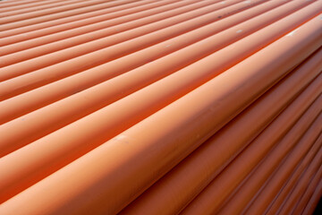 Stack of Orange pipe made of polyvinyl chloride