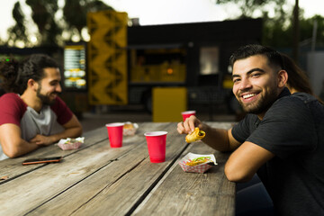 Attractive hispanic man enjoying eating mexican tacos