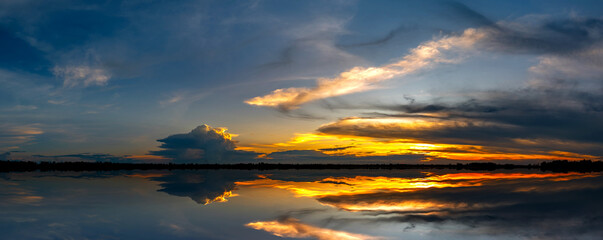 Panorama Reflection of vivid sunset sky over sea.Colorful sunrise with Clouds over ocean.