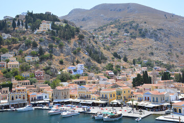 Fototapeta na wymiar greek island Symi with boats, multicolored buildings and hills view from top