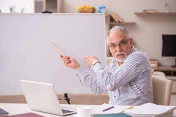 Old male employee working from home during pandemic