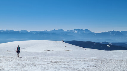 Woman hiking in snow covered landscape near Ladinger Spitz, Saualpe, Lavanttal Alps, Carinthia,...