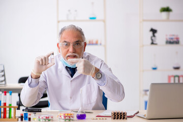 Old male chemist in drug synthesis concept