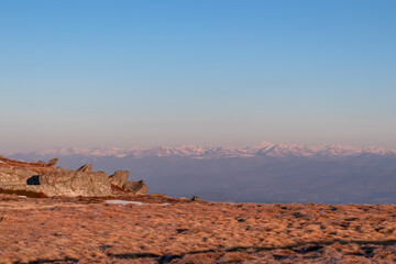 Scenic view of rock formation and Karawanks mountains at sunrise seen from alpine meadow at...