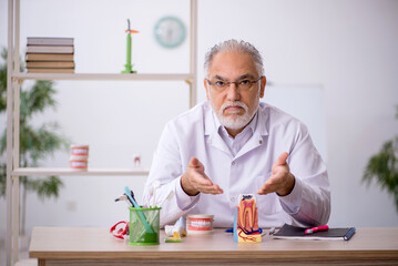 Old male dentist working in the clinic