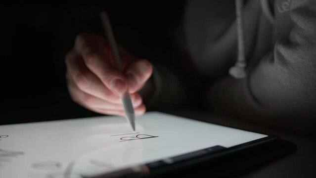 Man writes the word "Buy" on a tablet using a special pencil, digital drawing