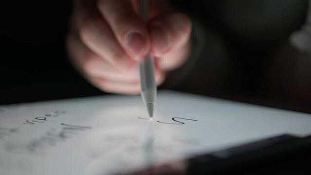 Man writes the word "SELL" on a tablet using a special pencil, digital drawing