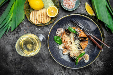 Italian risotto with shrimps, mussels, octopus, clams and glass of white wine, Restaurant menu, dieting, cookbook recipe top view