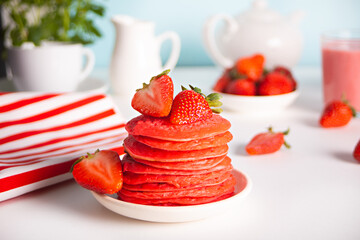 Pink red stack tasty homemade pancakes with fresh strawberries.