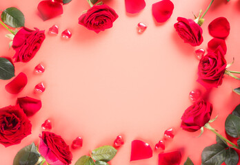 Frame of red roses and heart on pink background. Top view. Copy space. Valentines day concept.
