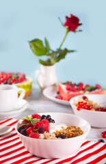 Granola, muesli cereals with yogurt or milk and fresh berries. Healthy breakfast concept.