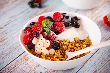 Granola, muesli cereals with yogurt or milk and fresh berries. Healthy breakfast concept.