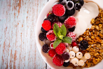 Granola, muesli cereals with yogurt or milk and fresh berries. Healthy breakfast concept.