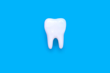 A molar on a blue background in the center of the image. Medical concept of dental health and proper care of molars. Inspection of the root of the tooth. Perfect molar on isolated background