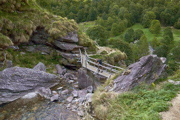 Fototapeta premium mature man old bridge, Sonogno, Switzerland