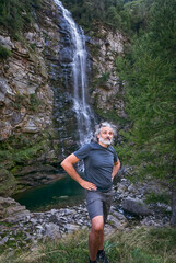 Naklejka na ściany i meble Mature man Waterfall, Sonogno, Switzerland