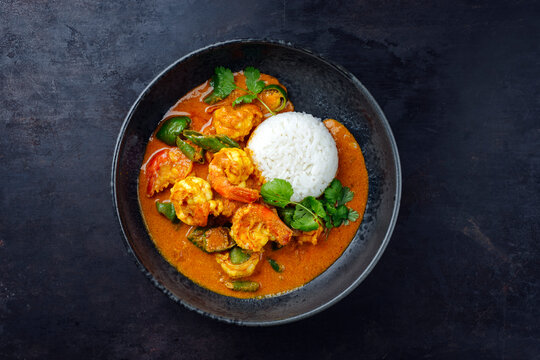 Traditional Thai kaeng phet red curry with chili and basmati rice served as top view in a Nordic design bowl with copy space