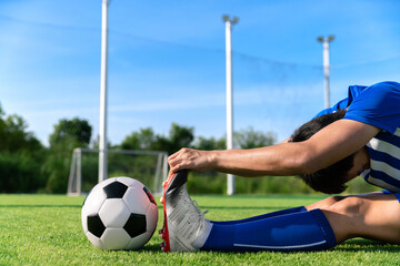 football soccer player stretching during warm up before kick ball in match league in stadium with healthy sport concept
