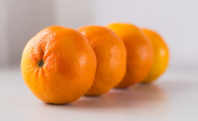 appetizing tangerines laid out in a row on white background