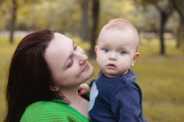 Happy family mother and baby hugging outdoor