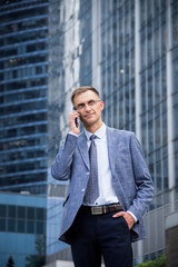 Business man with a phone in his hands on the background of the building