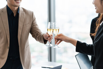 group of Asian business people holding glasses of wine to celebrate new year