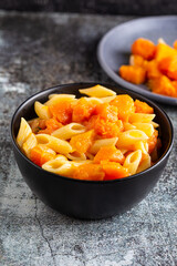 Penne pasta with pumpkin, typical autumn food. Ideal for vegan and vegetarian people.