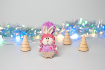 Handmade knitted bunny on a New Year's blurred background