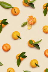 Orange yellow juicy tangerines with green leaves, whole and peeled on neutral beige background, geometric pattern. Citrus fruits mandarins, healthy fruits food concept, creative photo, top view