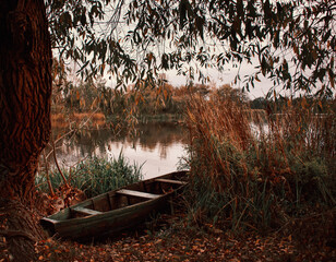 autumn landscape on the river with a boat