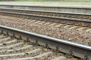 Railroad tracks with gravel, transport. Railway rails on concrete sleepers, selective focus.