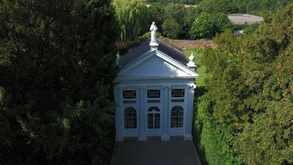 Aerial top down view from the drone onto the narrow passageway leading to a small chapel. Chapel located in a big green open area of fields near Rosary Manor, Mill Hill, North West London, London, UK.