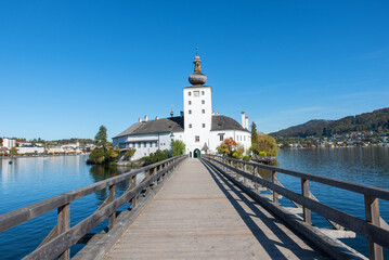 Fototapeta na wymiar bridge to Ort Castle, lake Traunsee, tourist destination gmunden, Salzkammergut