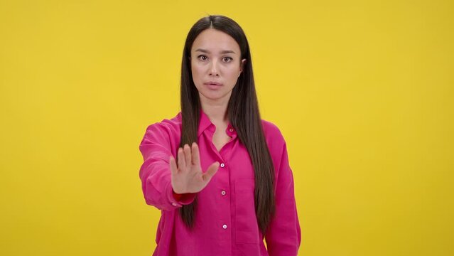 Serious woman shakes head and shows stopping gesture