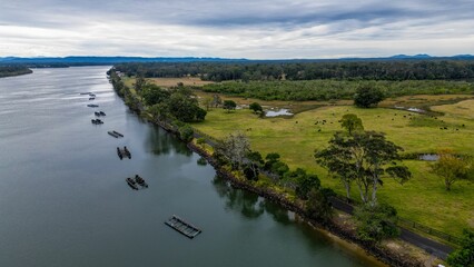 Aerial shot of Hastings River Port with scenic mountains and cloudscape in the background