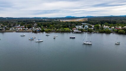 Fototapeta na wymiar Aerial shot of Hastings River Port with scenic mountains and cloudscape in the background