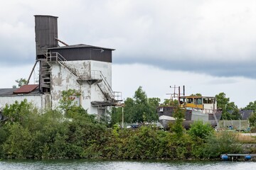 Beautiful shot of old mill and boat on green grass river shore