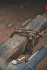 Closeup shot of rusty metal chain rolling on aged metal pump