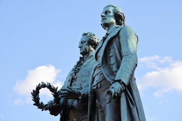 Closeup of Goethe-Schiller-Denkmal monument on blue cloudy sky background in Germany