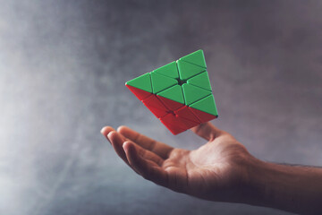 Floating Triangle Puzzle Cube on hand trying to solve	
