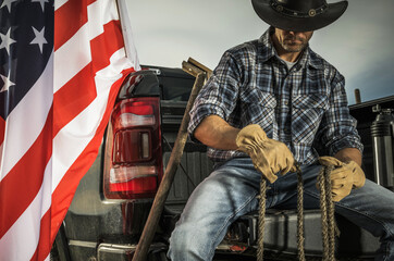 Cowboy Rancher Seating on His Pickup Truck Cargo Bed with a Rope in His Hands © Tomasz Zajda
