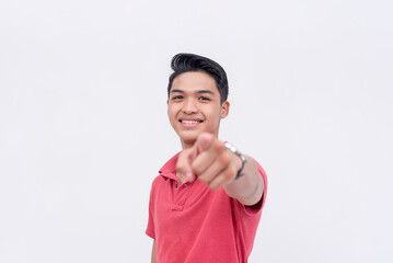 A friendly asian man points to the camera while smiling. Endorsing someone. Isolated on a white...