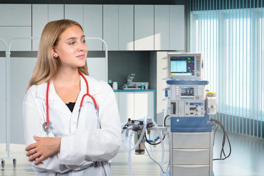 Doctor anesthesiologist. Woman and equipment for introduction of anesthesia. Girl doctor stands with her arms crossed. Woman anesthesiologist at workplace. Anesthesiologist in doctors white coat