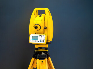Geodetic instrument. Technologies for geodesist. Yellow topographic equipment. Geodetic technologies. Geodetic equipment on tripod. Modern optical theodolite on dark. Device for creating maps