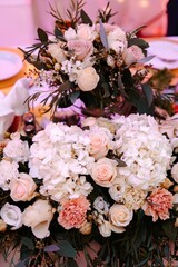 Vertical shot of a fresh bouquet of beautiful roses, carnations, hydrangeas for decorating a table